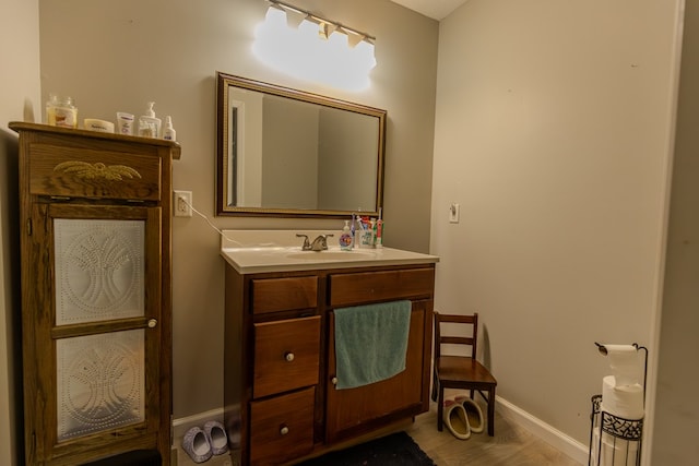 bathroom with baseboards, wood finished floors, and vanity