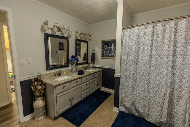 full bathroom featuring a textured ceiling, double vanity, a sink, and crown molding