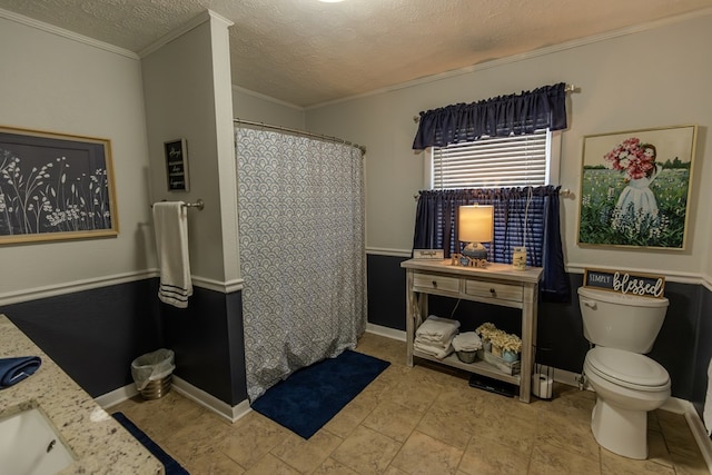 full bath featuring a shower with shower curtain, toilet, vanity, crown molding, and a textured ceiling