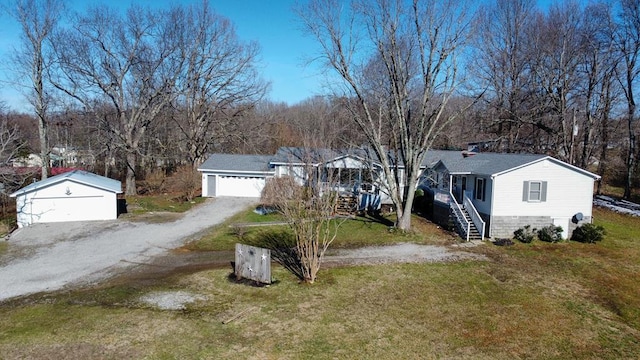 view of front facade featuring dirt driveway, stairway, and a front lawn