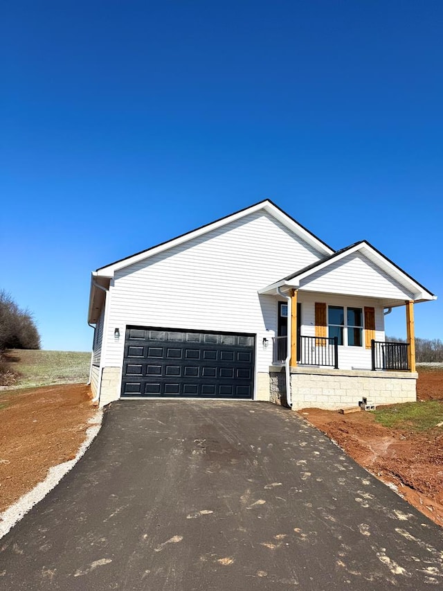 view of front of house featuring a garage, aphalt driveway, and a porch