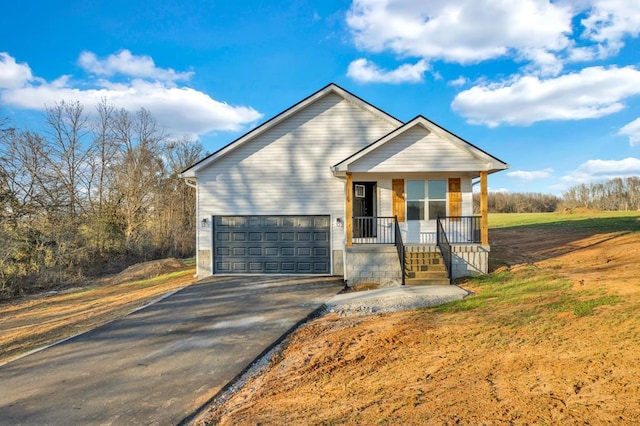 view of front of home featuring covered porch, driveway, and a garage