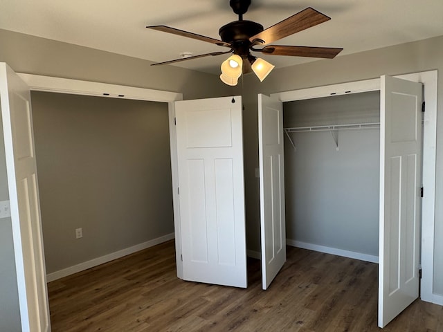 interior space featuring a ceiling fan, a closet, dark wood finished floors, and baseboards