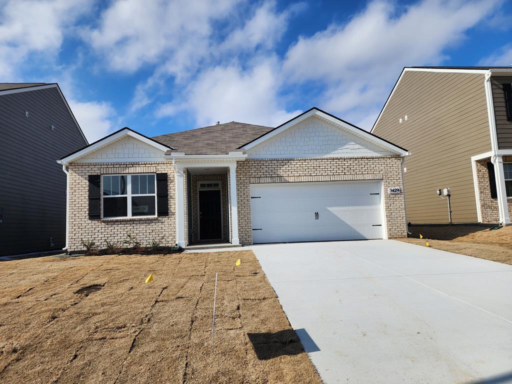 single story home with an attached garage, driveway, and brick siding