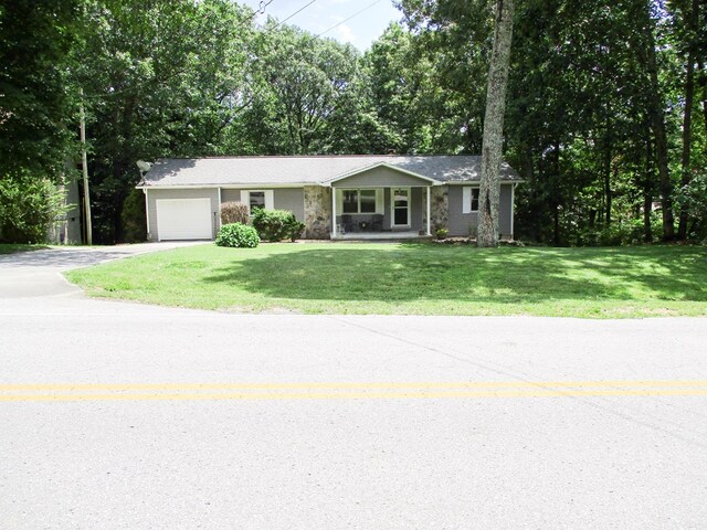 ranch-style home with a garage, a front yard, and driveway