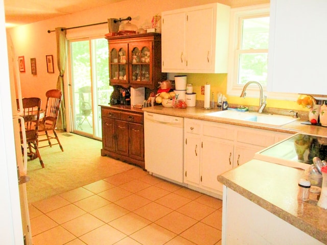 kitchen with light carpet, white cabinets, dishwasher, light countertops, and a sink