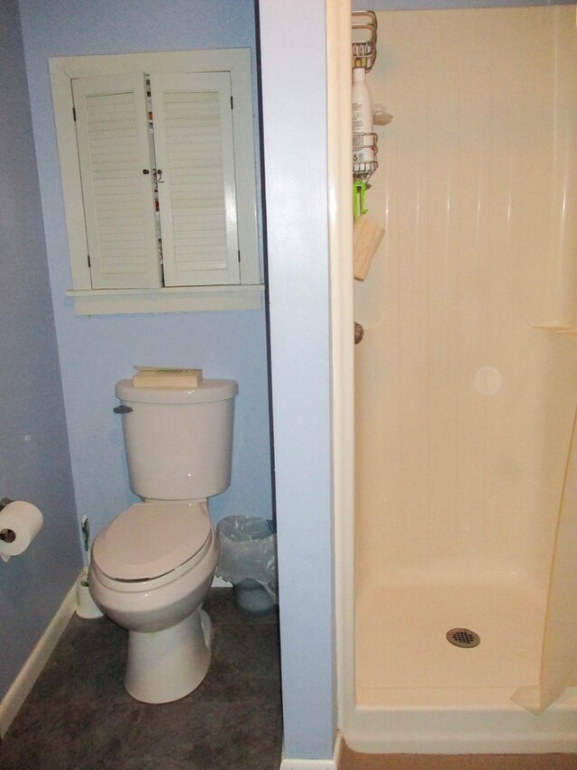 full bath with a shower stall, toilet, and baseboards