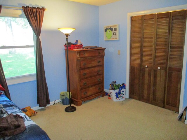 bedroom featuring a closet and light carpet