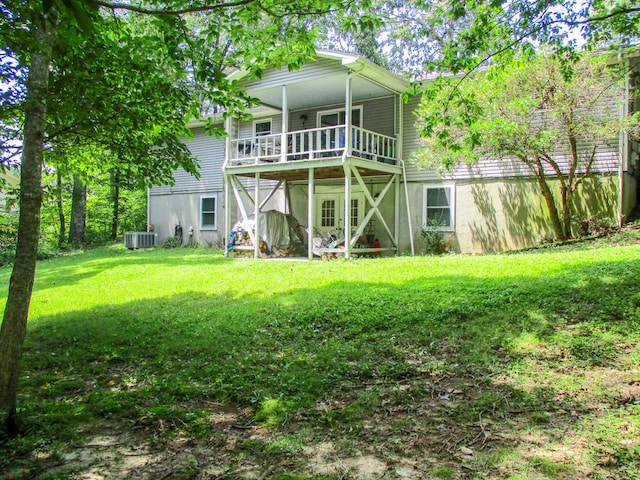 back of property featuring central AC unit and a yard