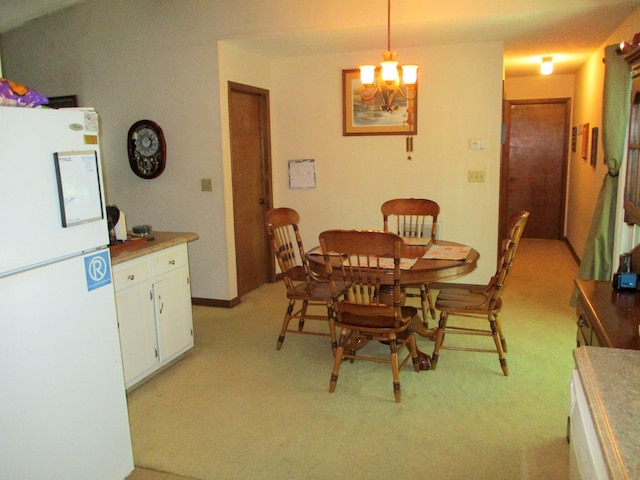 dining room with light colored carpet, baseboards, and an inviting chandelier