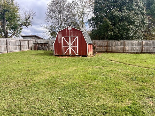 view of yard featuring an outbuilding, a fenced backyard, and a storage unit