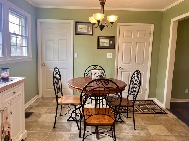 dining room featuring baseboards, visible vents, a chandelier, and crown molding