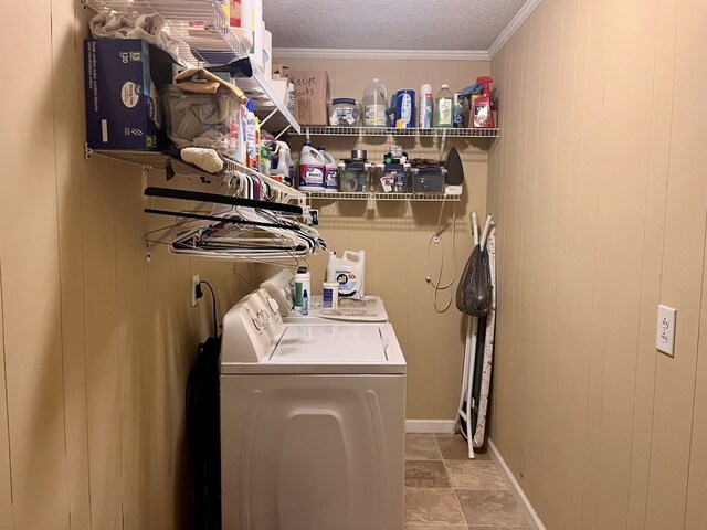 laundry room with laundry area, wooden walls, a textured ceiling, crown molding, and separate washer and dryer