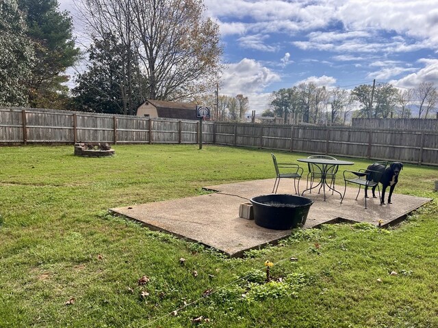 view of yard featuring a fire pit, a patio area, and a fenced backyard