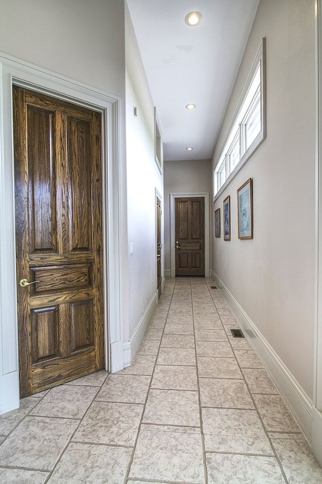 corridor with recessed lighting and baseboards