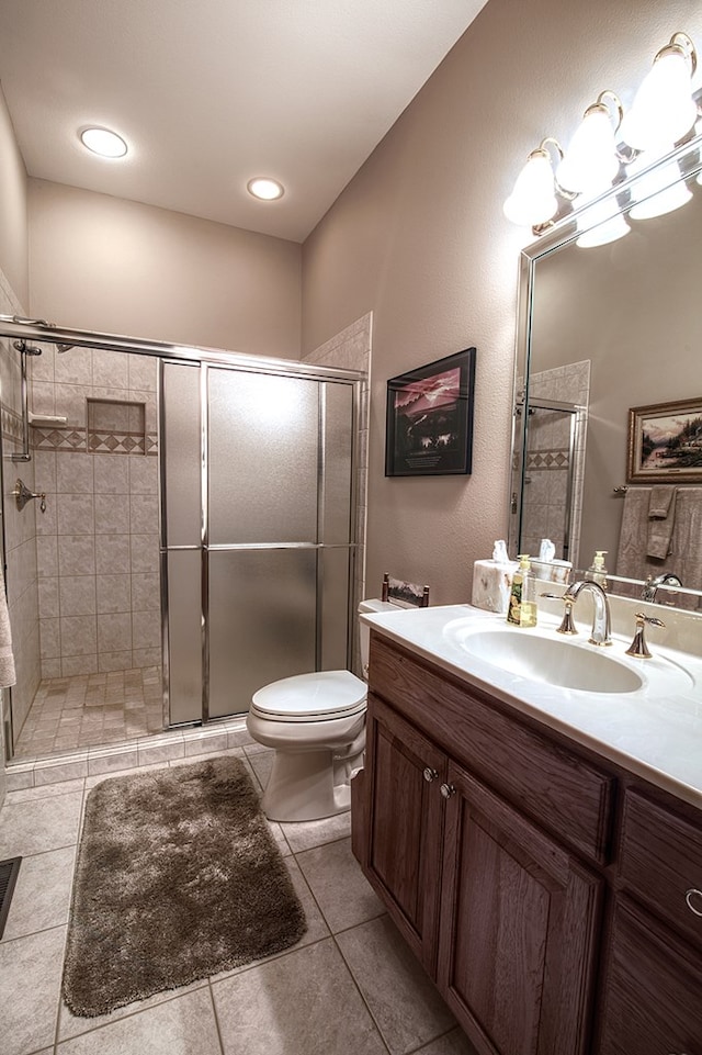 full bathroom with tile patterned flooring, toilet, a notable chandelier, vanity, and a stall shower