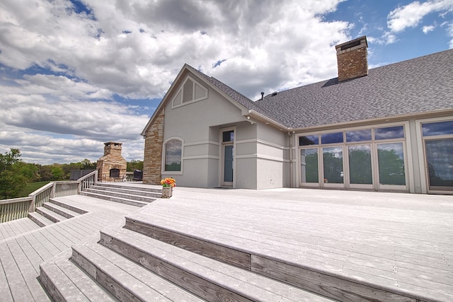 deck with an outdoor stone fireplace