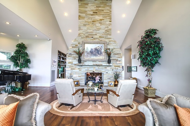 living room featuring a towering ceiling, baseboards, and wood finished floors