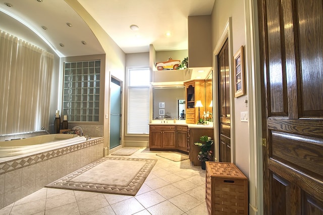 bathroom with a garden tub, tile patterned flooring, and vanity