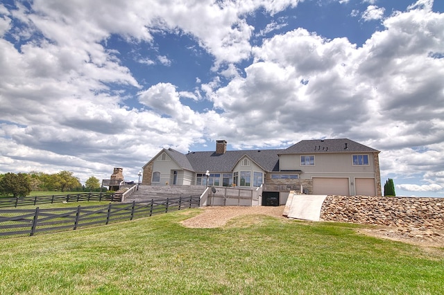 view of yard featuring a garage, fence, and a rural view