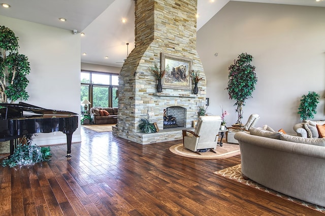 living room with a high ceiling, a fireplace, and wood finished floors