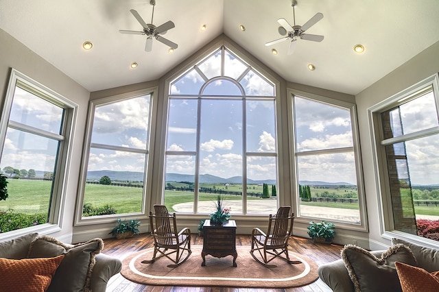 sunroom featuring a mountain view, vaulted ceiling, and a ceiling fan