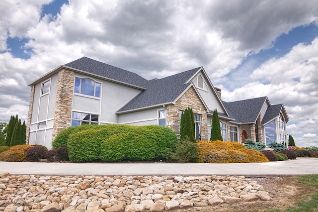 view of home's exterior featuring stone siding and stucco siding