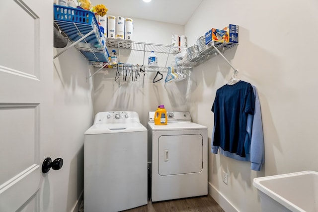 laundry area featuring wood finished floors, baseboards, laundry area, a sink, and washer and dryer