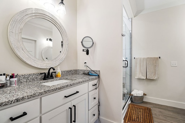 full bath featuring baseboards, a shower stall, wood finished floors, and vanity