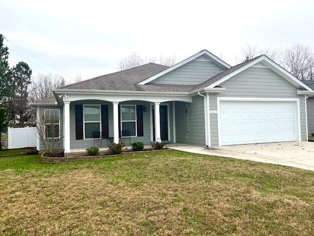 ranch-style house with a garage, a porch, a front yard, and fence