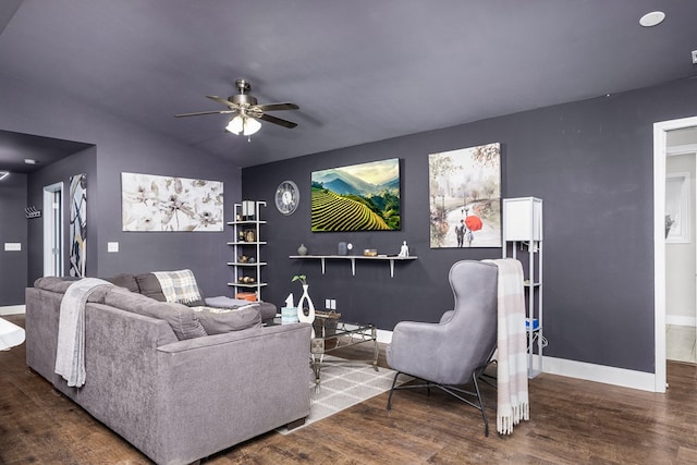 living room featuring a ceiling fan, vaulted ceiling, baseboards, and wood finished floors