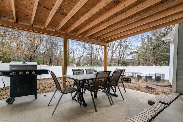 view of patio featuring outdoor dining space, a fenced backyard, and grilling area