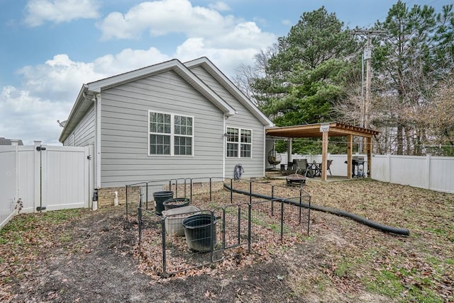 rear view of house featuring cooling unit, a fenced backyard, and a gate