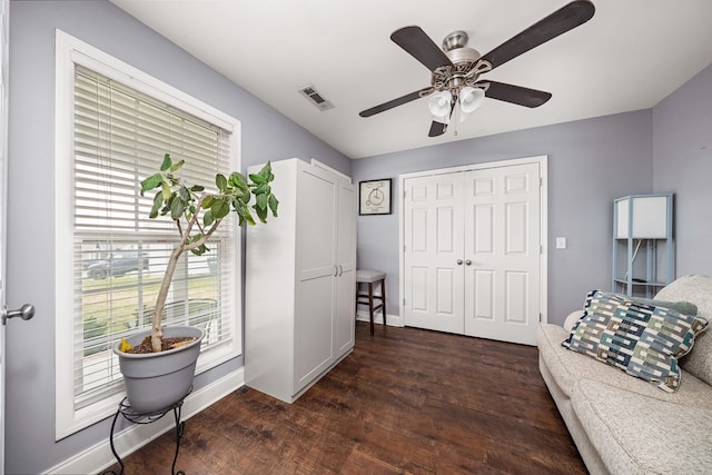 living area with a ceiling fan, baseboards, visible vents, and wood finished floors