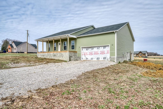 ranch-style home with covered porch, driveway, and an attached garage