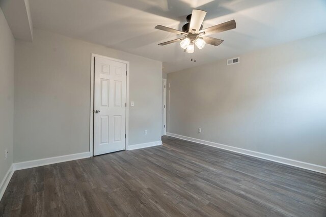 interior space with baseboards, visible vents, ceiling fan, and dark wood-style flooring