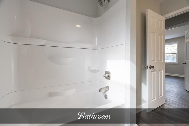 full bathroom featuring bathing tub / shower combination, baseboards, and wood finished floors