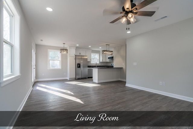 unfurnished living room featuring dark wood-style flooring, recessed lighting, visible vents, a ceiling fan, and baseboards