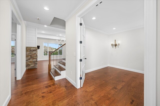 interior space featuring ornamental molding, a notable chandelier, baseboards, and wood finished floors