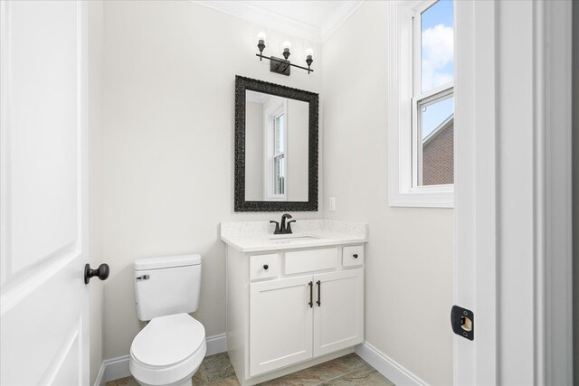 bathroom with toilet, baseboards, ornamental molding, and vanity