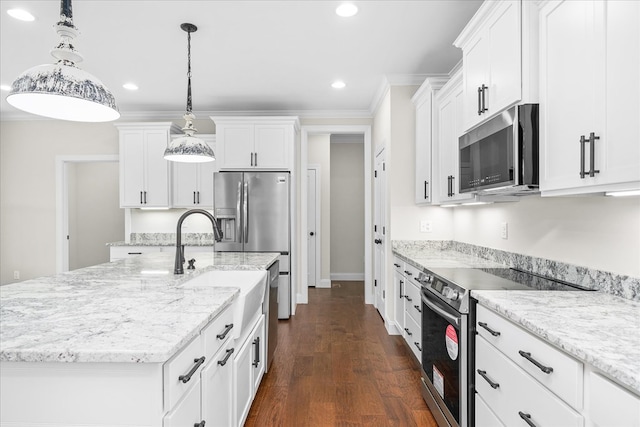 kitchen with stainless steel appliances, white cabinets, decorative light fixtures, and a center island with sink