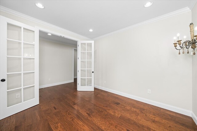 unfurnished room with crown molding, dark wood finished floors, recessed lighting, an inviting chandelier, and baseboards