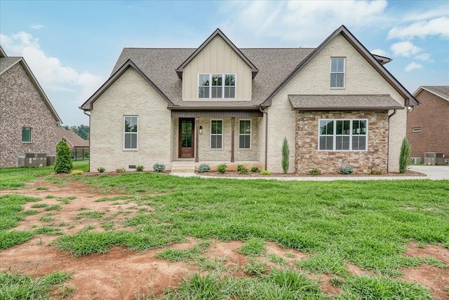 view of front facade featuring a shingled roof, central AC unit, a front lawn, and brick siding