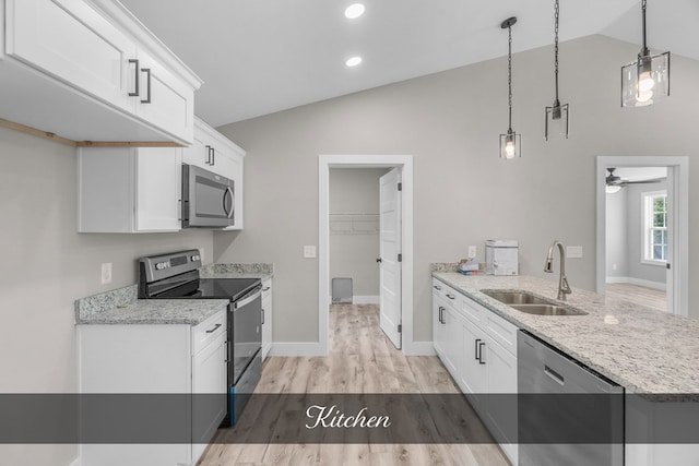 kitchen with stainless steel appliances, hanging light fixtures, a sink, and white cabinets