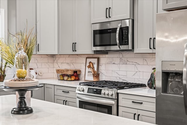 kitchen with decorative backsplash, appliances with stainless steel finishes, and gray cabinets