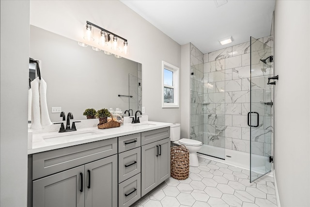 bathroom featuring double vanity, toilet, a stall shower, and a sink