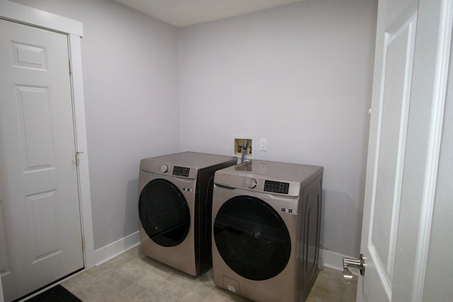 laundry room featuring washing machine and dryer, laundry area, and baseboards