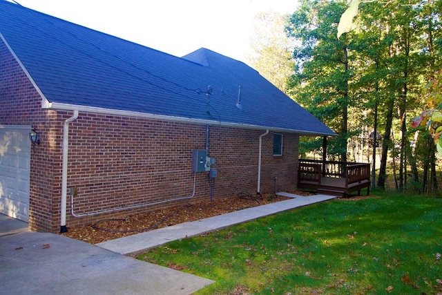 view of property exterior with a garage, a deck, a lawn, and brick siding