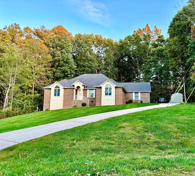 ranch-style home featuring a front yard, concrete driveway, brick siding, and crawl space