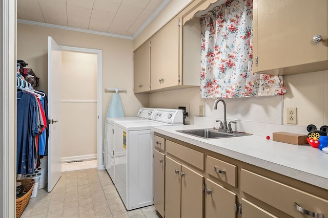 washroom featuring cabinet space, crown molding, washer and dryer, and a sink